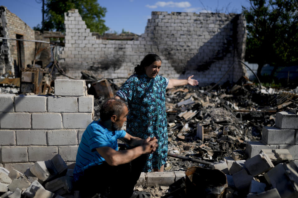 Nastasia Vladimirovna shows part of her house destroyed by attacks beside her husband Syvak Andrey Vladimirovich in Mostyshche, on the outskirts of Kyiv, Ukraine, Monday, June 6, 2022. Vladimirovna lived there with 18 members of her family but now she is staying with her husband on her neighbor's home. (AP Photo/Natacha Pisarenko)