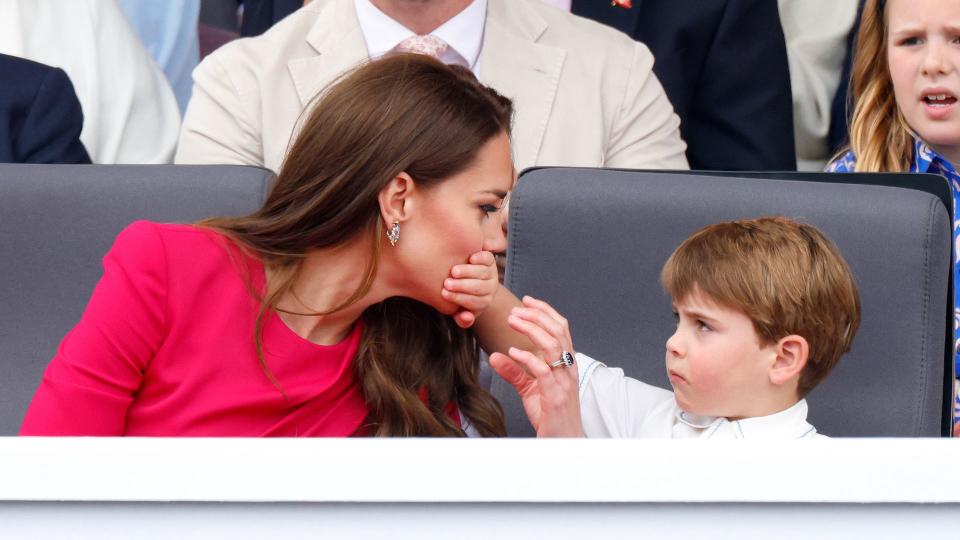 Prince Louis with his hand over Kate's mouth