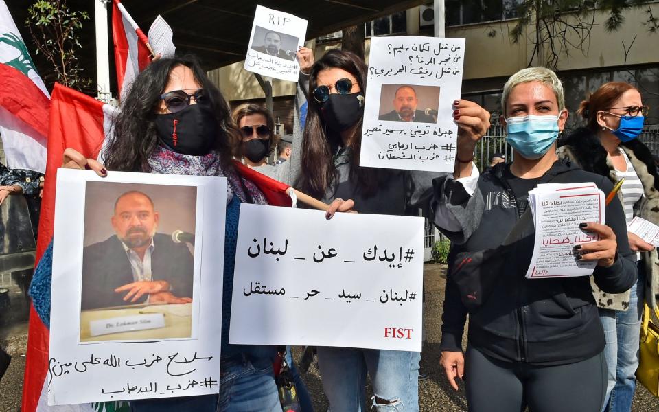 Protesters hold photos of murdered Lebanese activist and intellectual Lokman Slim during a rally in Beirut