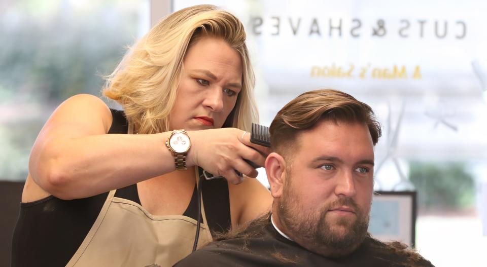 Derek Turner has his hair cut by the owner, 	Molly Prescott, early Friday morning at Faded Cuts and Shaves on South South Street in Gastonia.