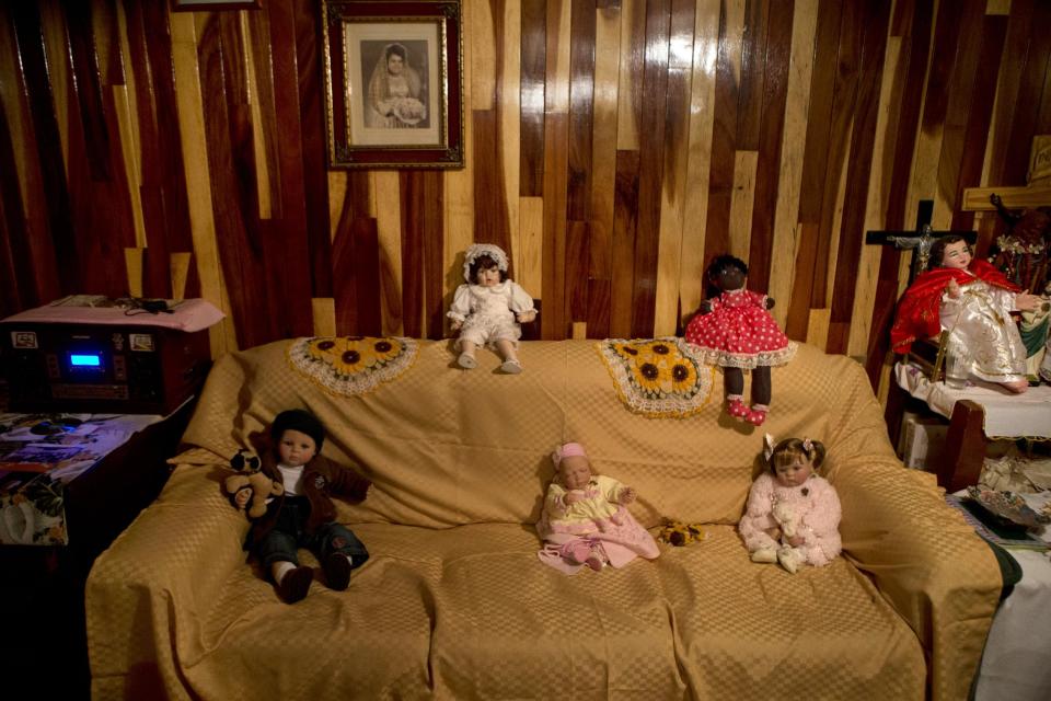 In this April 11, 2014 photo, dolls sit on a couch in the apartment of Lourdes Ruiz in Tepito's Fortaleza housing complex in Mexico City. A small theater company led by one of the countryís best-known actors recently began leading groups of people on evening walks and motorcycle rides through Tepito to show them the human side of a neighborhood identified with crime and poverty. (AP Photo/Rebecca Blackwell)