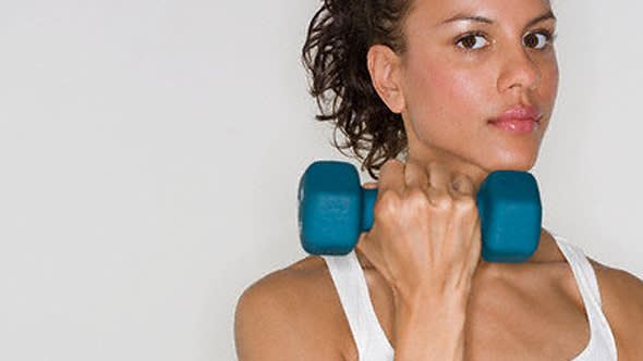 Young Woman Lifting Dumbbell --- Image by ? Royalty-Free/Corbis