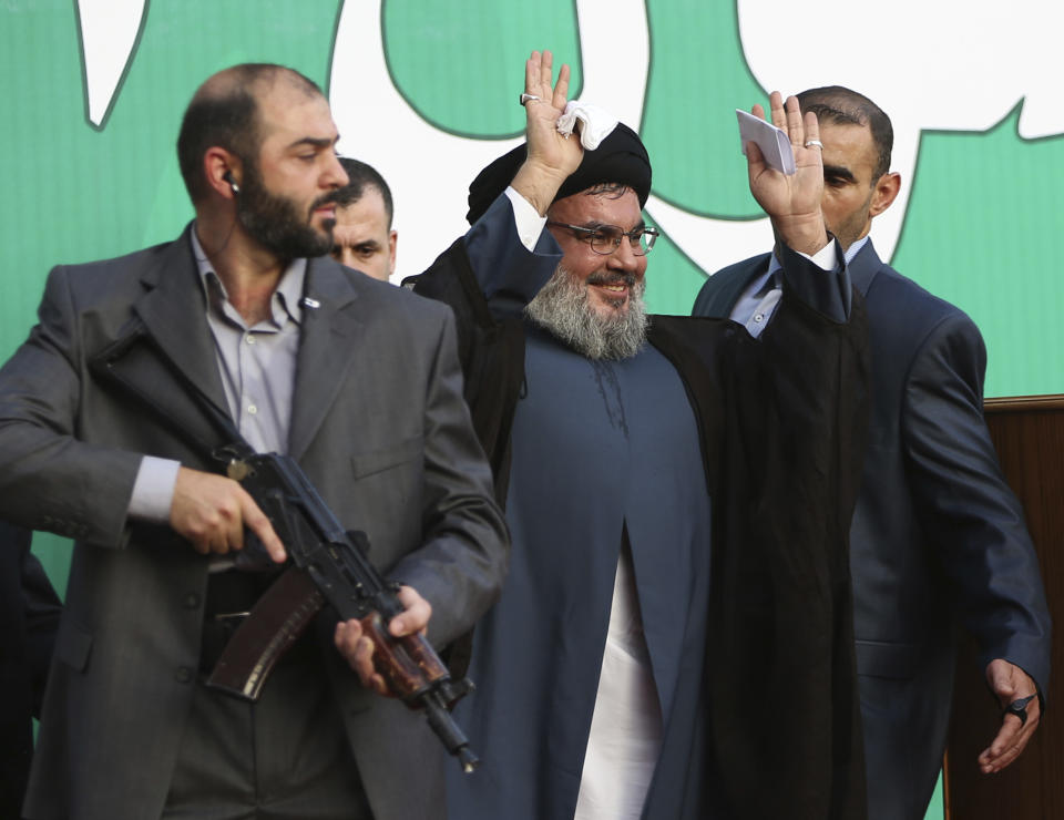 FILE - Hezbollah leader Sheik Hassan Nasrallah, center, escorted by his bodyguards, waves to a crowd of tens of thousands of supporters during a rally denouncing an anti-Islam film that has provoked a week of unrest in Muslim countries worldwide, in a southern suburb of Beirut, Lebanon, Sept. 17, 2012. Forty years since it was founded, Lebanon's Hezbollah has transformed from a ragtag organization to the largest and most heavily armed militant group in the Middle East. (AP Photo/Hussein Malla, File)