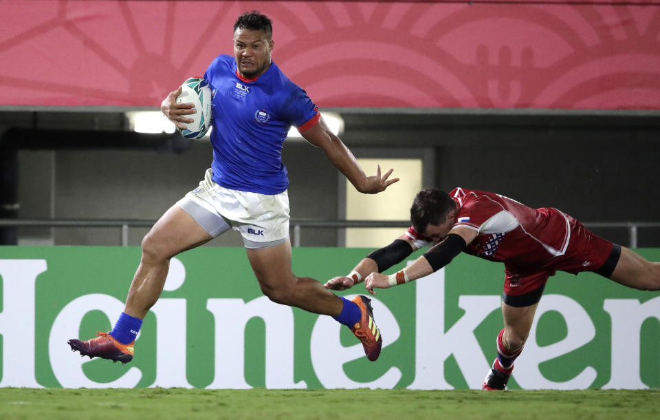 Samoa's Alapati Leiua runs past Russia's Vasily Artemyev to score a try during the Rugby World Cup Pool A game between Russia and Samoa at Kumagaya Rugby Stadium, Kumagaya City, Japan, Tuesday, Sept. 24, 2019. Samoa defeated Russia 34-9. (AP Photo/Jae Hong)