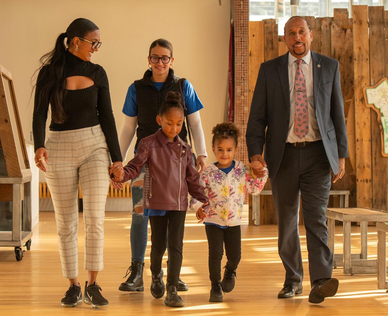 Khrystian King arrives to vote with his family at the Blackstone Heritage Corridor Visitor Center Tuesday. King’s wife, Tatiana King, and their daughter, Leiyani, 7, were joined by Tatiana’s sister, Elyse Pena, and her daughter, Janae, 4, left to right.