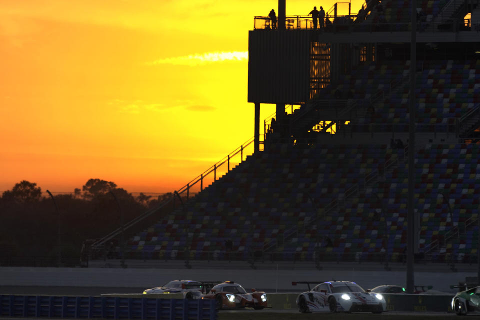 Cars navigate the infield road course as the sun sets during the Rolex 24 hour auto race at Daytona International Speedway, Saturday, Jan. 30, 2021, in Daytona Beach, Fla. (AP Photo/John Raoux)