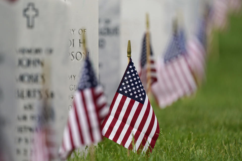 FILE - Flags and tributes mark the Memorial Day holiday at Fort Logan National Cemetery in southeast Denver, May 31, 2021. A new report and Pentagon data show that suicides across the active duty U.S. military decreased over the past 18 months, driven by sharp drops in the Air Force and Marine Corps last year and a similar decline among Army soldiers during the first six months of this year. (AP Photo/David Zalubowski, File)