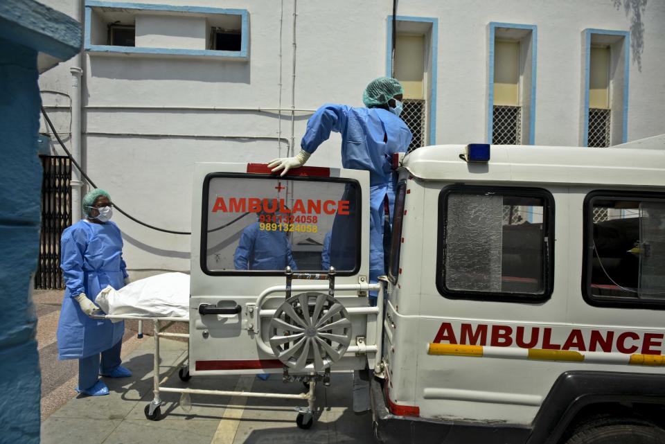 NEW DELHI, INDIA - JUNE 10:  Health workers wheel the body of a man who died due to coronavirus into an ambulance at Lok Nayak Jai Prakash (LNJP) Hospital as it is taken for cremation,  on June 10, 2020 in New Delhi, India. The city Wednesday reported 1,501 fresh cases, taking the total case count to 32,810. The state health department cleared its backlog of previous Covid-19 deaths, adding 79 more deaths. The toll is now 984, taking the fatality rate to almost 3%.(Photo by Biplov Bhuyan/Hindustan Times via Getty Images)