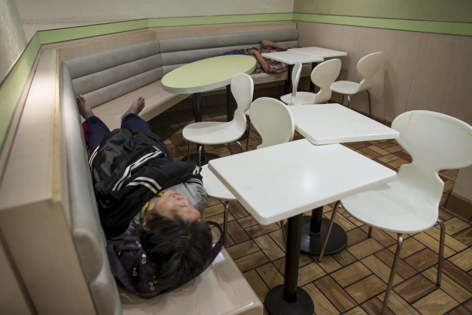 Men sleep at a 24-hour McDonald's restaurant in Hong Kong, China