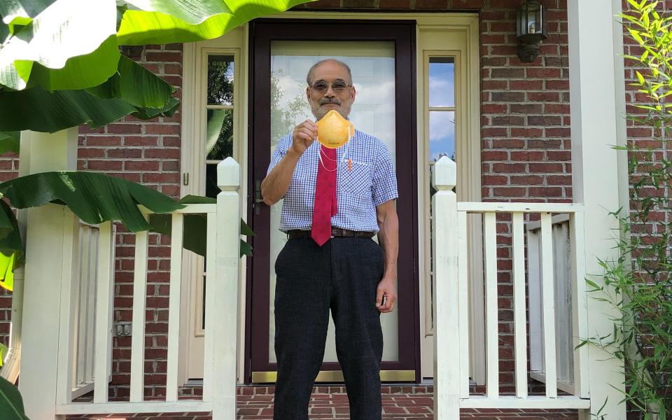 Peter Tsai holding up an N95 face mask - Peter Tsai