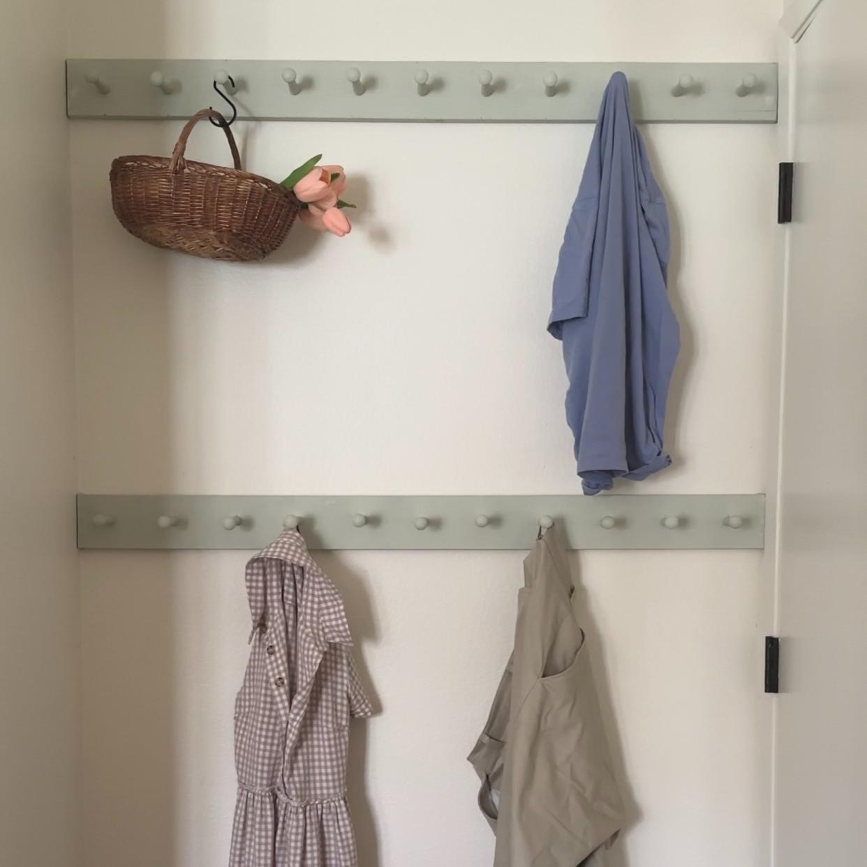  A DIY peg rail used as an alternative to a chair covered in clothes. 