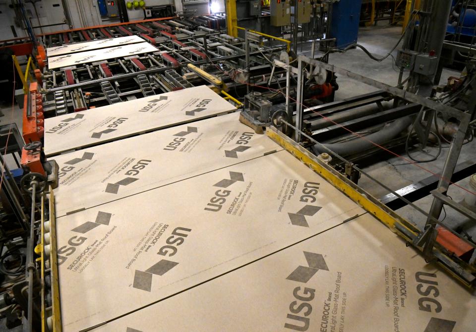 Gypsum wallboard, known under the brand name as Sheetrock, rolls down one of the manufacturing lines at the United States Gypsum factory in Sweetwater Tuesday.