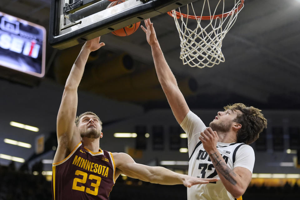 Iowa forward Owen Freeman (32) blocks a shot by Minnesota forward Parker Fox (23) during the first half of an NCAA college basketball game, Sunday, Feb. 11, 2024, in Iowa City, Iowa. (AP Photo/Charlie Neibergall)