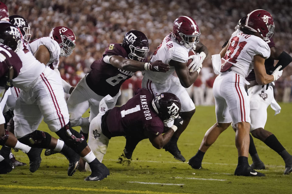 Alabama running back Brian Robinson Jr. (4) is tackled short of the goal line by Texas A&M linebacker Aaron Hansford (1) and defensive lineman DeMarvin Leal (8) during the first half of an NCAA college football game Saturday, Oct. 9, 2021, in College Station, Texas. (AP Photo/Sam Craft)