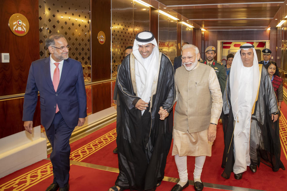 In this photo released by the state-run WAM news agency, Indian Prime Minister Narendra Modi, second from right, walks with Khaldoon Khalifa al-Mubarak, second from left, chairman of the Abu Dhabi Executive Affairs Authority, after arriving in Abu Dhabi, United Arab Emirates, Friday, Aug. 23, 2019. Modi is on a trip to both the United Arab Emirates and Bahrain, reinforcing ties between India and the Gulf Arab nations as he pursues stripping statehood from the disputed Muslim-majority region of Kashmir. (WAM via AP)