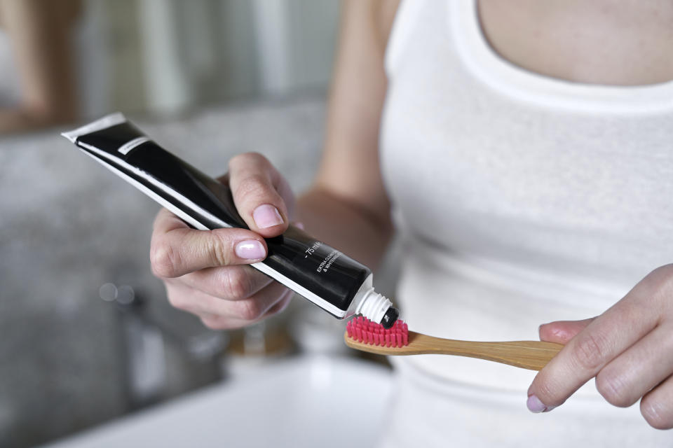 charcoal toothpaste going onto a toothbrush