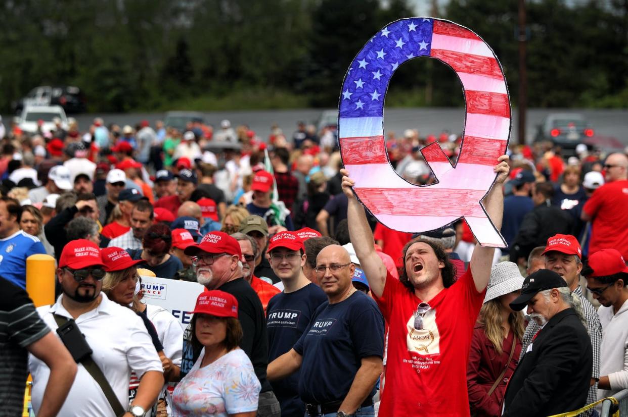 <span class="caption">A QAnon supporter waiting to see Donald Trump at a rally in Pennsylvania.</span> <span class="attribution"><a class="link " href="https://www.gettyimages.com/detail/news-photo/david-reinert-holds-up-a-large-q-sign-while-waiting-in-line-news-photo/1009769482?adppopup=true" rel="nofollow noopener" target="_blank" data-ylk="slk:Rick Loomis/Getty Images;elm:context_link;itc:0;sec:content-canvas">Rick Loomis/Getty Images</a></span>