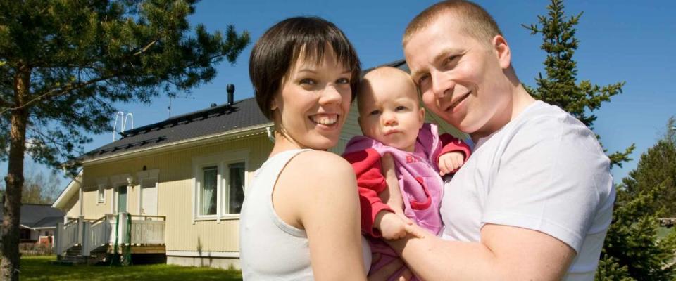 Happy family in front of their home