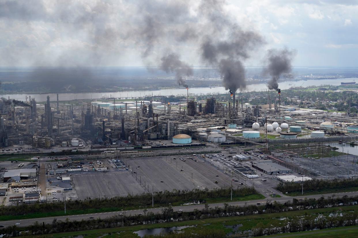 Flares burn at the Shell Norco Manufacturing Complex on Aug. 31, 2021, in Norco, La. Each ton of carbon dioxide that exits a smokestack or tailpipe is doing far more damage than what governments take into account, researchers conclude in a scientific paper published Thursday, Sept. 1, 2022. 