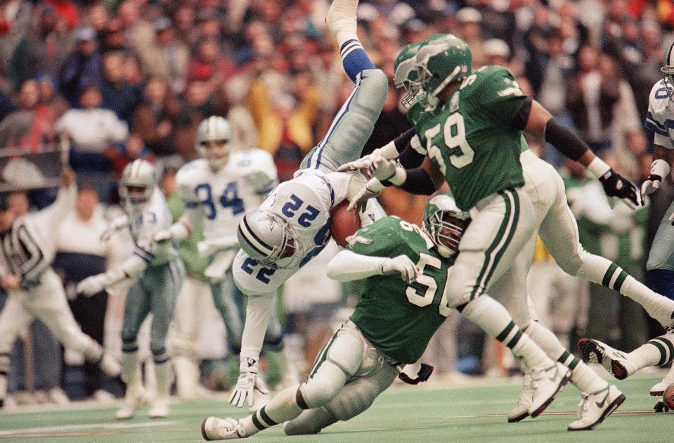 Dallas Cowboys running back Emmitt Smith (22) sails over Philadelphia Eagles linebacker Byron Evans (56) with help from Eagle's Seth Joyner (59) in the first quarter of the NFC play off game, Sunday, Jan. 10, 1993 in Irving, Taxes Smith gained 16 yards on the play.