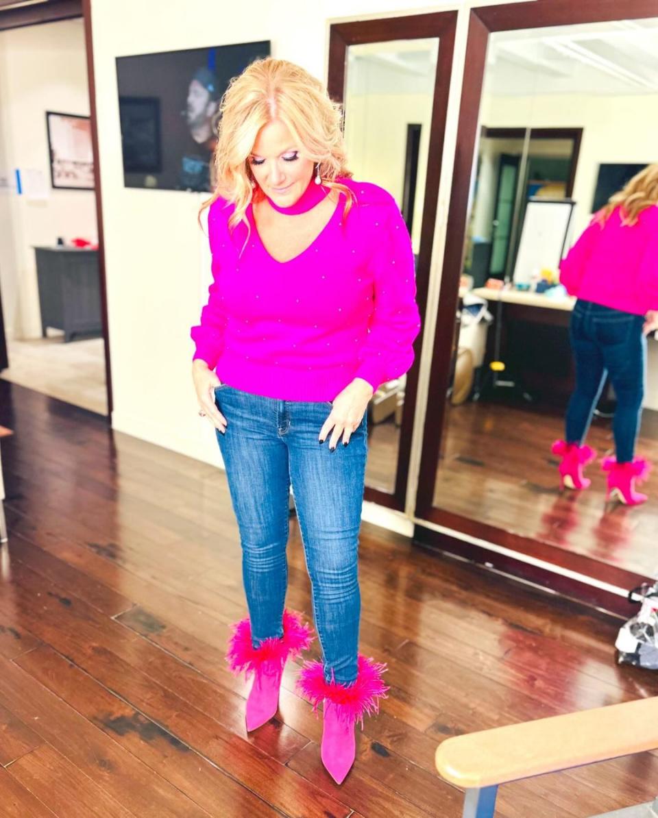 Trisha Yearwood wears pink sweater with blue jeans and pink heels