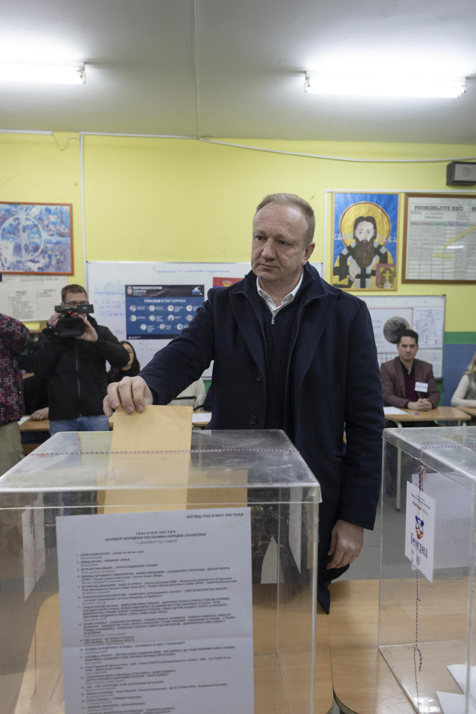 Dragan Djilas, front, the main opposition coalition leader, gets ready to cast his vote at the early parliamentary elections in Belgrade, Serbia, Sunday, Dec. 17, 2023. Serbia's populist President Aleksandar Vucic is looking to further tighten his firm grip on power in the Balkan state in an election on Sunday that has been marred by reports of major irregularities during a tense campaign. (AP Photo/Marko Drobnjakovic)