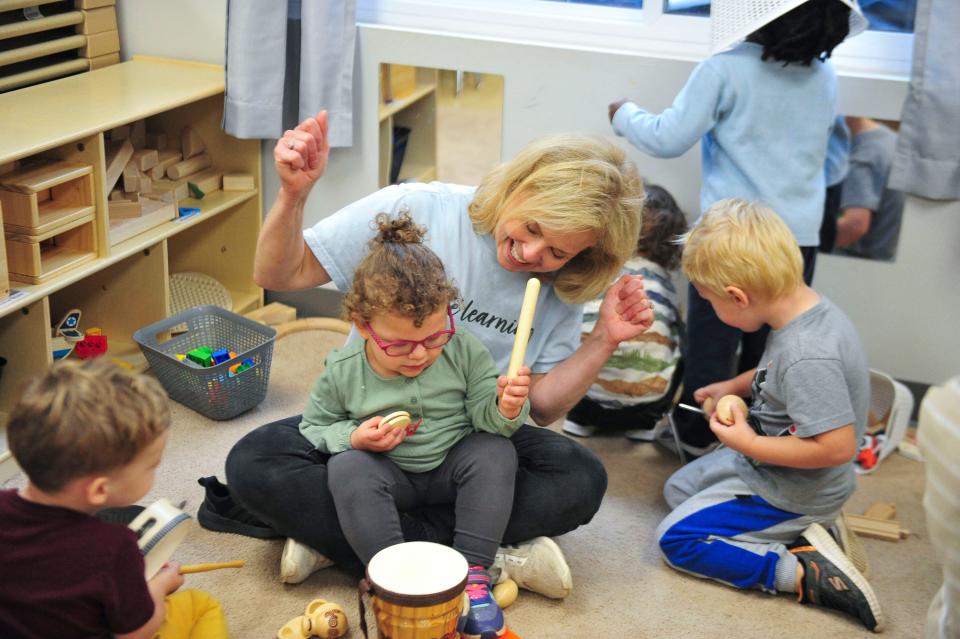 A teacher and student play the drums at the Olive Tree Early Learning Academy.