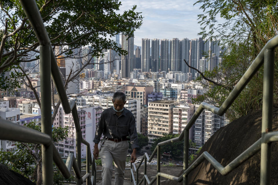 A man climbs steps near residential housing in Hong Kong, Wednesday, Oct. 19, 2022. Hong Kong's leader on Wednesday unveiled a new visa scheme to woo global talent, as the city seeks to stem a brain drain that has risked its status as an international financial center. (AP Photo/Vernon Yuen)