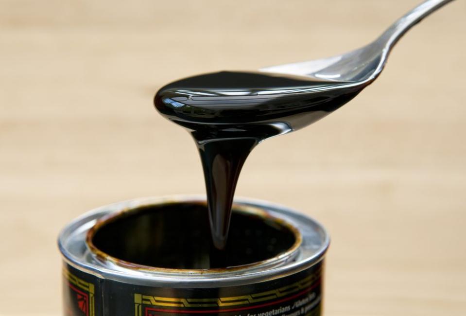 Spoonful of black treacle oozing off of spoon