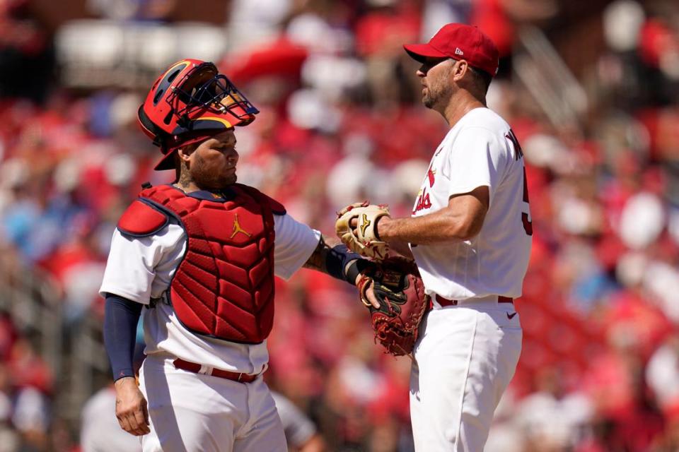 Former St. Louis Cardinals catcher Yadier Molina, left, talks to starting pitcher Adam Wainwright during a game against the Washington Nationals last season. Wainwright, in his final MLB season, suffered a groin injury and will miss several weeks to begin the 2023 campaign.