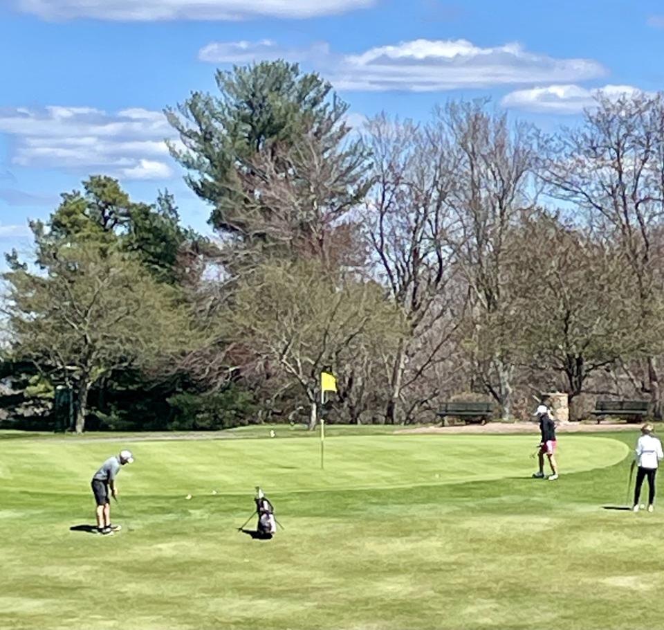 Golfers chip on the 12th green at Wachusett Country Club.