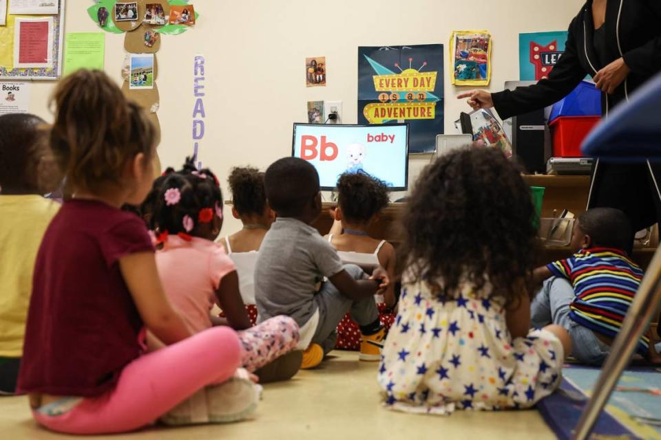 Kids in the three and four-year-old classroom watch a video to learn how the alphabet in sign language at Lollipops daycare.