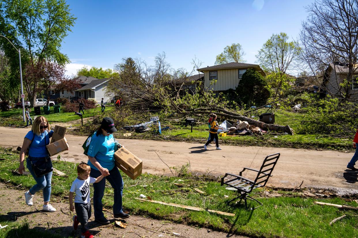 Residents clean up debris in Pleasant Hill, Iowa, on Saturday, April 27, 2024, after multiple tornadoes ripped across the state Friday evening.