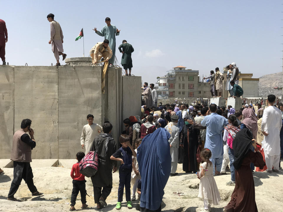 People struggle to cross the boundary wall of Hamid Karzai International Airport to flee the country after rumors that foreign countries are evacuating people even without visas, after the Taliban over run of Kabul, Afghanistan, 16 August 2021.  (Photo by STR/NurPhoto via Getty Images)