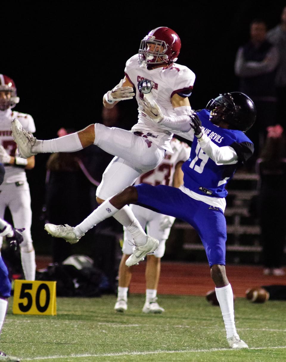 #7 Derek Lopes of Carver goes up for a pass but it is broken by Randolph's #19 Elijah Shabazz, both players going up high for the ball during the game on Thursday, Oct. 12, 2023. Shabazz ended up getting hurt on the play, and came off the field to be examined.