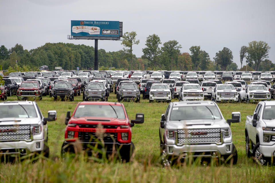 FILE - Flint-built trucks are parked in a vacant field off I-75 on Sept. 21, 2021 in Flint, Mich. The Chevrolet Silverados and GMC Sierra pickups built at Flint Assembly are waiting for semiconductors. Experts say unless more spending shifts back to services or something else motivates people to stop buying, it could take well into next year or even 2023 before the U.S. and global supply chains return to some semblance of normal. ( Jake May/The Flint Journal via AP)