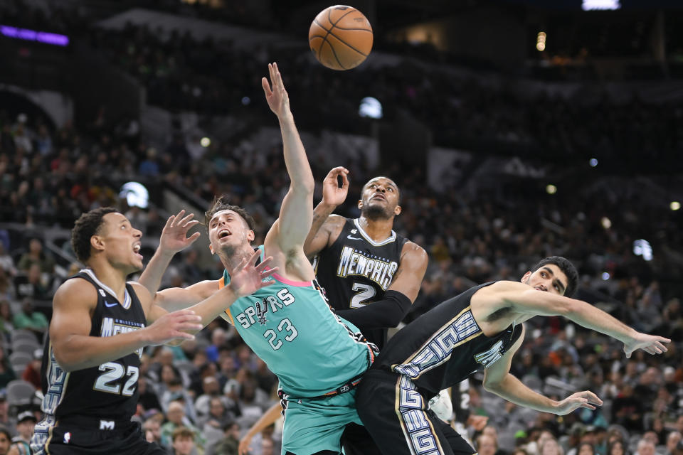 San Antonio Spurs' Zach Collins (23) is fouled by Memphis Grizzlies' Desmond Bane (22) as he goes to the basket during the first half of an NBA basketball game, Friday, March 17, 2023, in San Antonio. (AP Photo/Darren Abate)