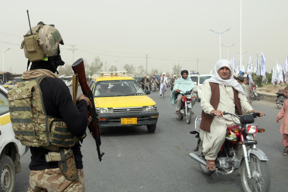 A Taliban fighter stands guard on the road during a celebration marking the second anniversary of the withdrawal of U.S.-led troops from Afghanistan, in Kandahar, south of Kabul, Afghanistan, Tuesday, Aug. 15, 2023. (AP Photo/Abdul Khaliq)