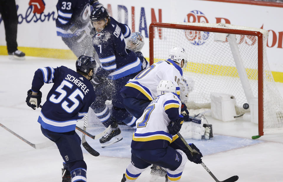 St. Louis Blues' Brayden Schenn (10) scores the tying goal against Winnipeg Jets goaltender Connor Hellebuyck (37) during the third period of Game 5 of an NHL hockey first-round playoff series Thursday, April 18, 2019, in Winnipeg, Manitoba. (John Woods/The Canadian Press via AP)