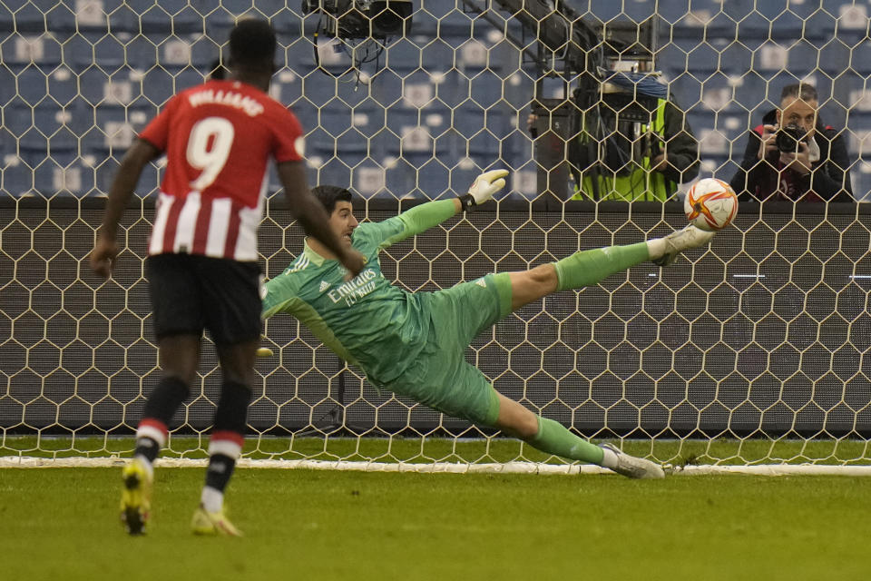 Real Madrid's goalkeeper Thibaut Courtois saves a penalty kick during the Spanish Super Cup final soccer match between Real Madrid and Athletic Bilbao at King Fahd stadium in Riyadh, Saudi Arabia, Sunday, Jan. 16, 2022. (AP Photo/Hassan Ammar)