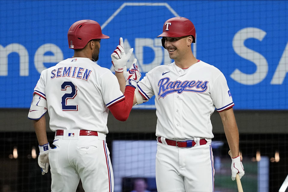 Texas Rangers' Marcus Semien (2) and Nathaniel Lowe, right, celebrate after Semien hit a solo home run against the Tampa Bay Rays during the third inning of a baseball game Tuesday, July 18, 2023, in Arlington, Texas. (AP Photo/Tony Gutierrez)