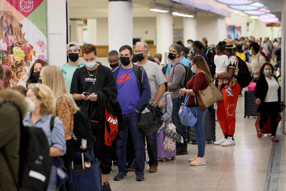 People wait in the line to travel through the TSA checkpoint at Miami International Airport on November 24, 2021 in Miami.  (Photo by Joe Raedle/Getty Images)