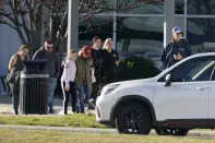 People leave the Dallas Executive Airport where two historic military planes crashed during an airshow, Saturday, Nov. 12, 2022. (AP Photo/LM Otero)