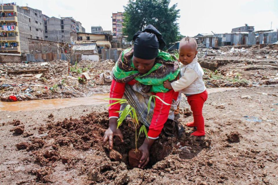 A Kenyan mother and her son plant a tree