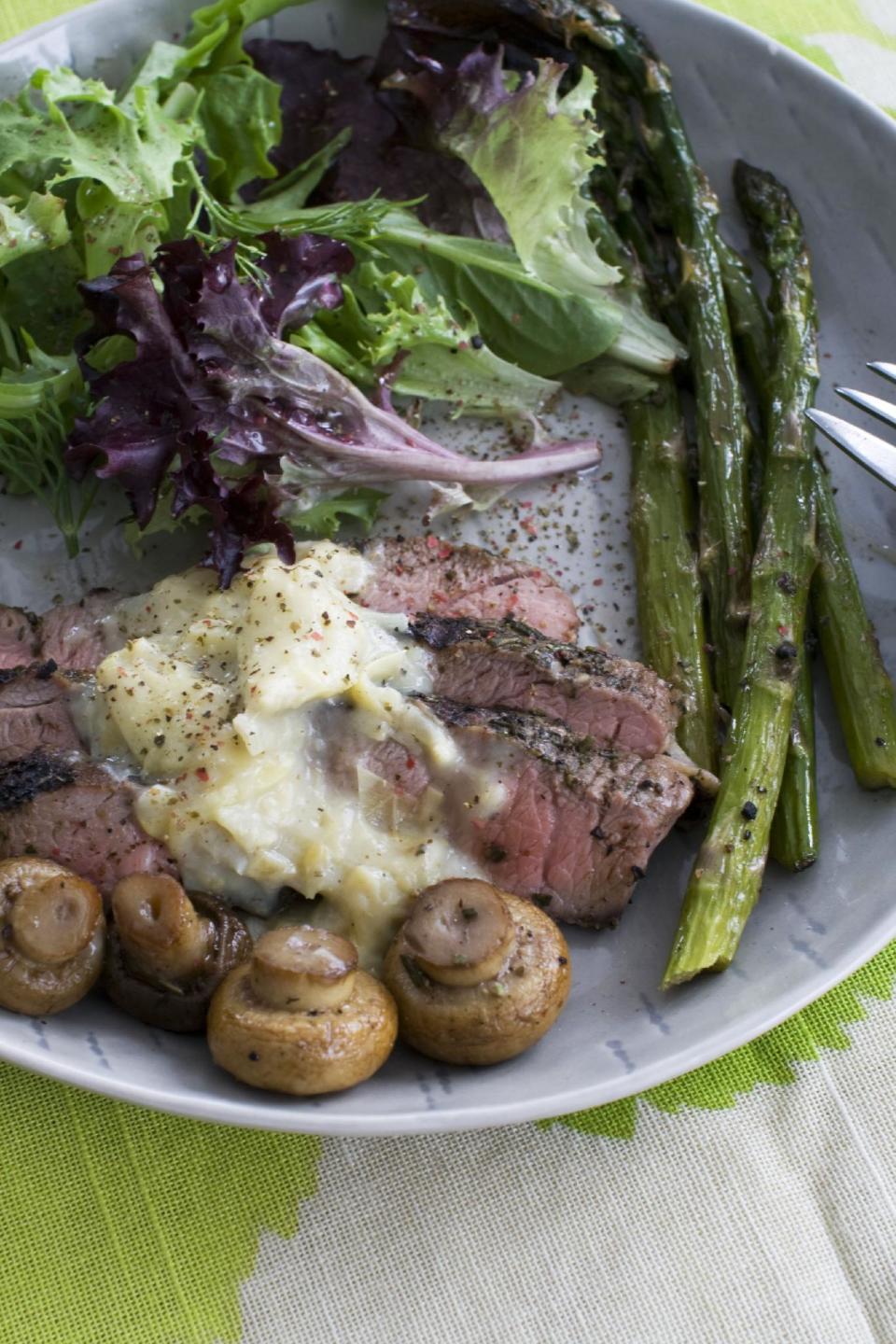 In this image taken on March 11, 2013, grilled lamb steaks with artichoke lemon sauce are shown served on a plate in Concord, N.H. (AP Photo/Matthew Mead)