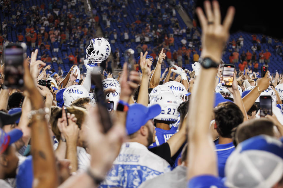 Fans and players celebrate on the field after Duke defeated Clemson in an NCAA college football game in Durham, N.C., Monday, Sept. 4, 2023. (AP Photo/Ben McKeown)