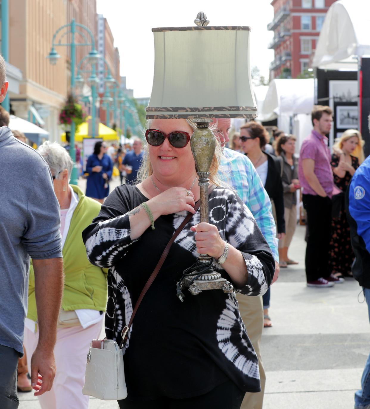 Jacqueline Harris of Sheboygan carries a lamp purchased at Retique Goodwill near the art show.