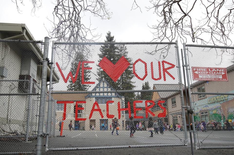 In this March 4, 2019, file photo, a sign supporting teachers is shown on a fence outside of Chabot Elementary School in Oakland, Calif. Alameda County is allowing middle and high schools to reopen.