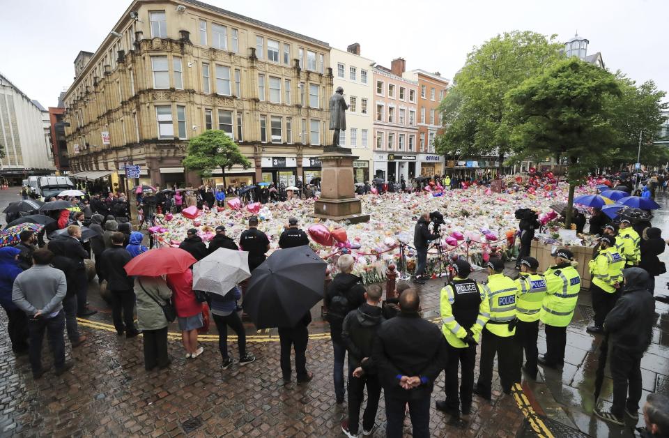 People observing a minute's silence in St Ann's Square, Manchester, England, in honour of the London Bridge terror attack victims, Tuesday June 6, 2017. A new search was underway Tuesday in a neighborhood near the home of two of the London Bridge attackers, hours after police said they had freed everyone detained in the wake of the rampage that left several dead and dozens wounded. (Peter Byrne/PA via AP)