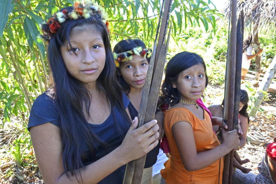 Young women from the Awa Indigenous group in Brazil return from a hunt with their bows and arrows. <a href="https://www.gettyimages.com/detail/news-photo/portrait-of-a-group-of-young-awa-women-adorned-with-toucan-news-photo/1258052224" rel="nofollow noopener" target="_blank" data-ylk="slk:Scott Wallace/Hulton Archive via Getty Images;elm:context_link;itc:0;sec:content-canvas" class="link ">Scott Wallace/Hulton Archive via Getty Images</a>